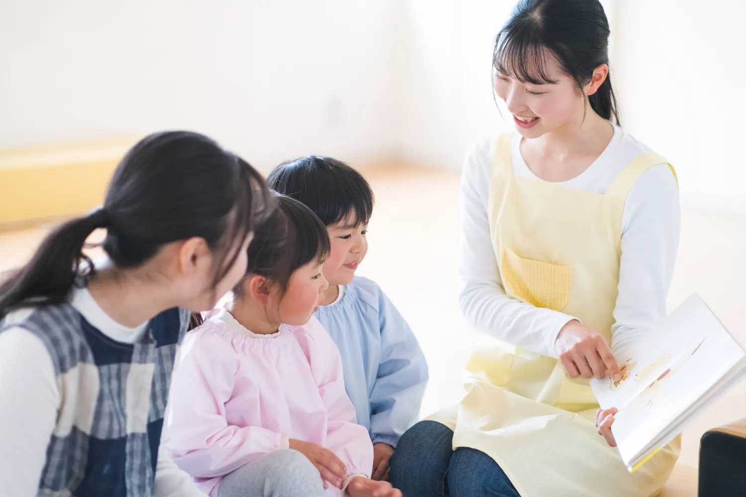 子どもたちに絵本を読む保育士
