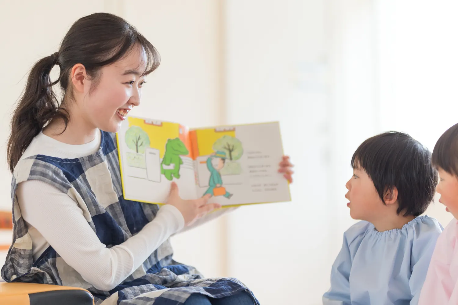 子どもたちに絵本を読む保育士